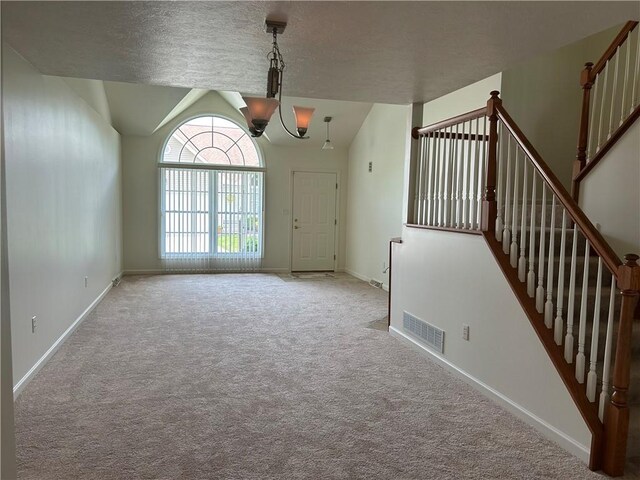 607 Crestview Ln, Lower Burrell, PA 15068 - unfurnished living room with carpet flooring, stairway, and a chandelier
