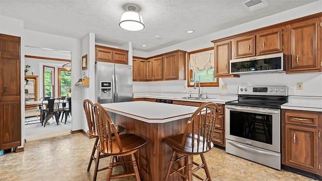 201 Clarke Rd, Buffalo Twp Wsh, PA 15323 - kitchen with appliances with stainless steel finishes, a sink, a kitchen bar, light countertops, and a textured ceiling