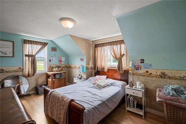 500 Kinsman Rd, Green Twp, PA 16134 - bedroom featuring multiple windows, wood finished floors, a textured ceiling, and lofted ceiling