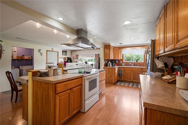 500 Kinsman Rd, Green Twp, PA 16134 - kitchen featuring white range with electric cooktop, island range hood, separate washer and dryer, brown cabinets, and light wood-type flooring