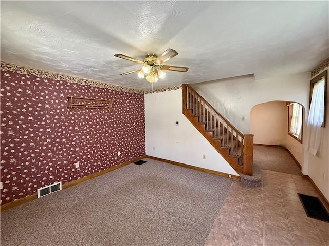 121-123 4th Ave, Scottdale, PA 15683 - unfurnished living room featuring wallpapered walls, a ceiling fan, stairway, baseboards, and carpet flooring