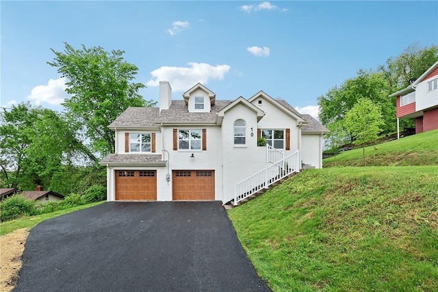 10 Neptune Dr, Robinson Twp Nwa, PA 15136 - view of front of home featuring driveway, a chimney, an attached garage, a front yard, and stucco siding