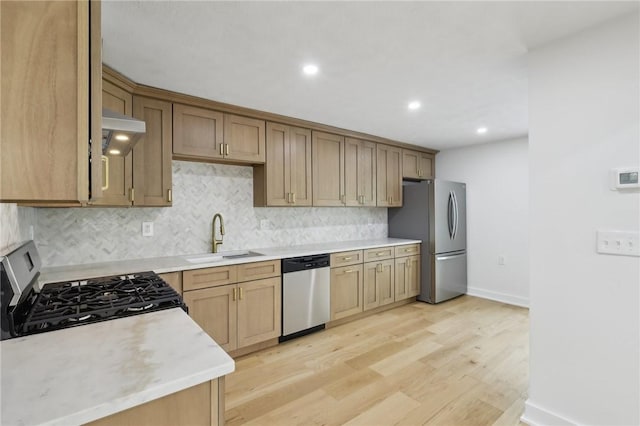 10 Neptune Dr, Robinson Twp Nwa, PA 15136 - kitchen featuring appliances with stainless steel finishes, light wood-style floors, decorative backsplash, under cabinet range hood, and light countertops