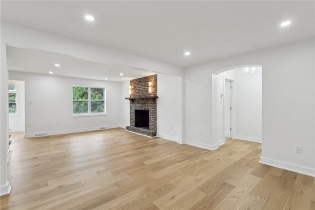 10 Neptune Dr, Robinson Twp Nwa, PA 15136 - unfurnished living room featuring light wood finished floors, arched walkways, a fireplace, and recessed lighting