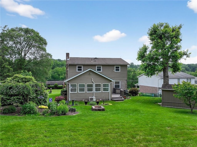 1990 Robbins Station Rd, North Huntingdon, PA 15642 - rear view of property with a chimney, a lawn, a storage shed, and a fire pit