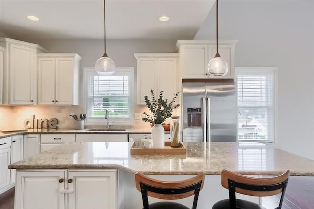 109 Summer Ln, Mount Pleasant Twp Was, PA 15057 - kitchen featuring stainless steel fridge with ice dispenser, white cabinets, light stone counters, a breakfast bar area, and decorative backsplash