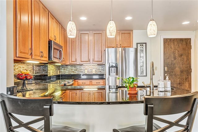306 4th Ave Unit 902, Downtown Pgh, PA 15222 - kitchen featuring stainless steel appliances, a breakfast bar area, decorative light fixtures, a peninsula, and decorative backsplash