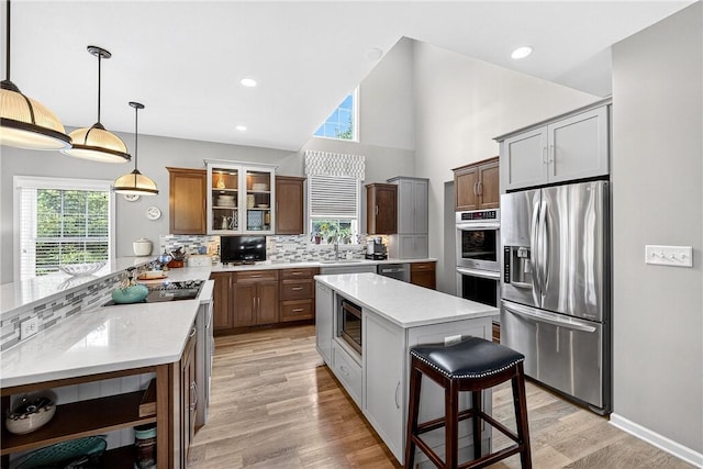 711 SE Simpson Howell, Elizabeth Twp/Boro, PA 15037 - kitchen featuring stainless steel appliances, a peninsula, decorative backsplash, a kitchen bar, and glass insert cabinets