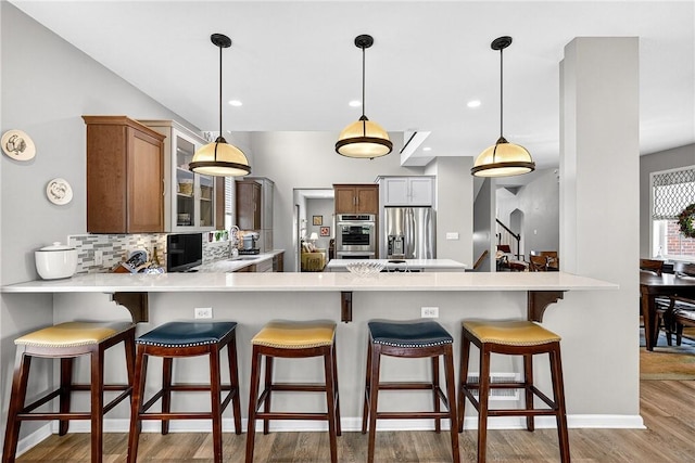 711 SE Simpson Howell, Elizabeth Twp/Boro, PA 15037 - kitchen with stainless steel appliances, a peninsula, decorative backsplash, wood finished floors, and recessed lighting