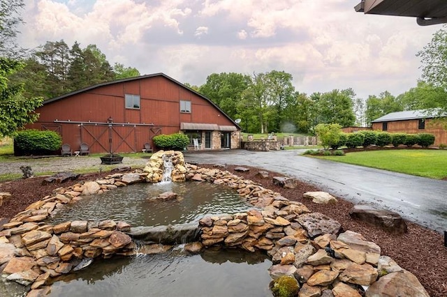 33 Chalkhill Ohiopyle Rd, Wharton Twp, PA 15470 - exterior space with a barn, a small pond, a detached garage, and an outbuilding
