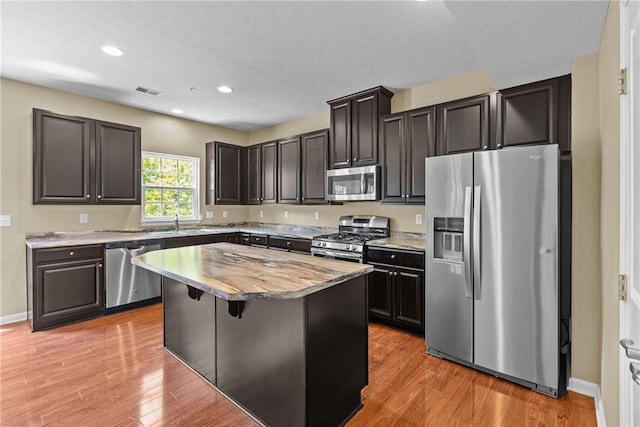 118 Maple Ridge Dr, Cecil, PA 15317 - kitchen with appliances with stainless steel finishes, a center island, light wood finished floors, recessed lighting, and a kitchen breakfast bar