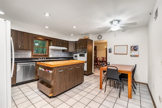 124 Oak Ln, Adams Twp, PA 16046 - kitchen featuring stainless steel appliances, wooden counters, under cabinet range hood, dark brown cabinets, and backsplash
