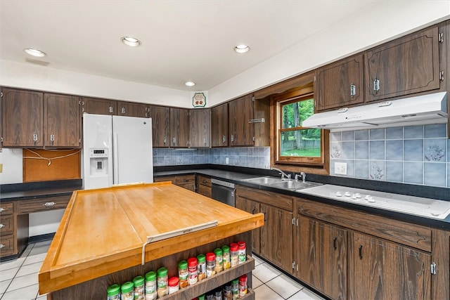 124 Oak Ln, Adams Twp, PA 16046 - kitchen with white appliances, light tile patterned floors, under cabinet range hood, dark brown cabinets, and backsplash