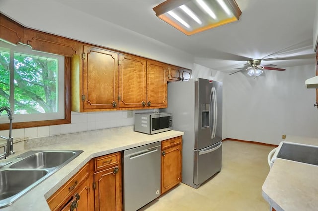 3473 Old Pulaski Rd, Wilmington Twp, PA 16105 - kitchen with stainless steel appliances, brown cabinetry, tasteful backsplash, light countertops, and a ceiling fan