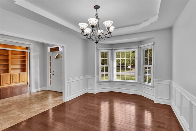 360 Steeplechase Dr, Cranberry Twp, PA 16066 - unfurnished dining area featuring a chandelier, hardwood / wood-style flooring, a tray ceiling, wainscoting, and a decorative wall