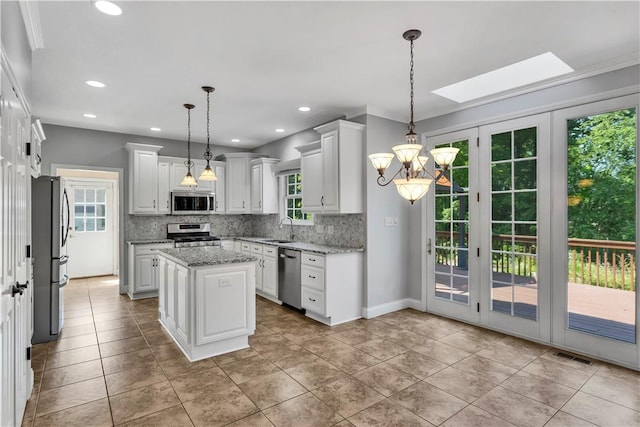 360 Steeplechase Dr, Cranberry Twp, PA 16066 - kitchen with stainless steel appliances, decorative backsplash, a skylight, white cabinetry, and a chandelier