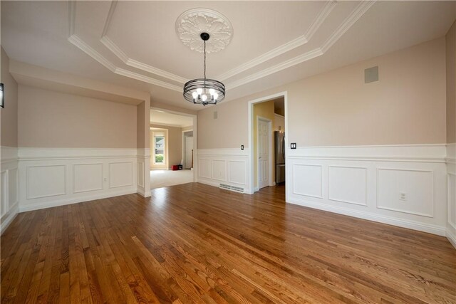 130 Sewickley Farm Cir, Marshall, PA 16046 - unfurnished dining area with a tray ceiling, wood-type flooring, a chandelier, crown molding, and a wainscoted wall