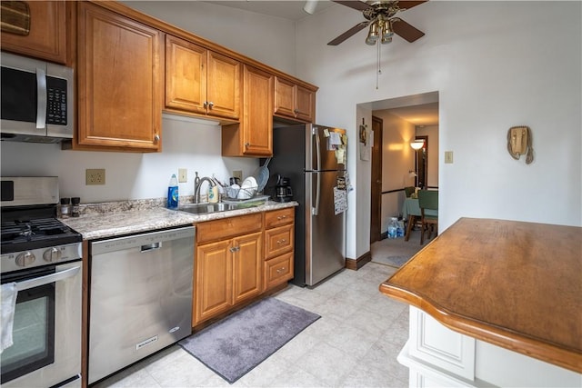 41 S 13th St, South Side, PA 15203 - kitchen with stainless steel appliances, a ceiling fan, light countertops, brown cabinets, and vaulted ceiling