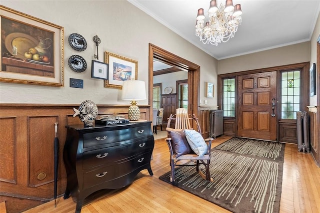 6909 Meade St, Point Breeze, PA 15208 - foyer entrance featuring light wood-style flooring, a chandelier, a wainscoted wall, and crown molding