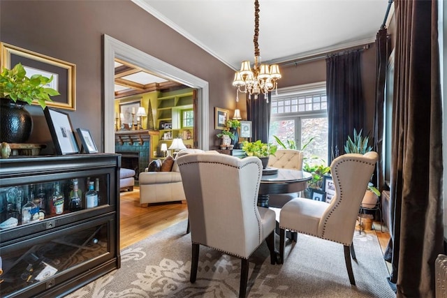 6909 Meade St, Point Breeze, PA 15208 - dining room featuring ornamental molding, a chandelier, wood finished floors, and a fireplace