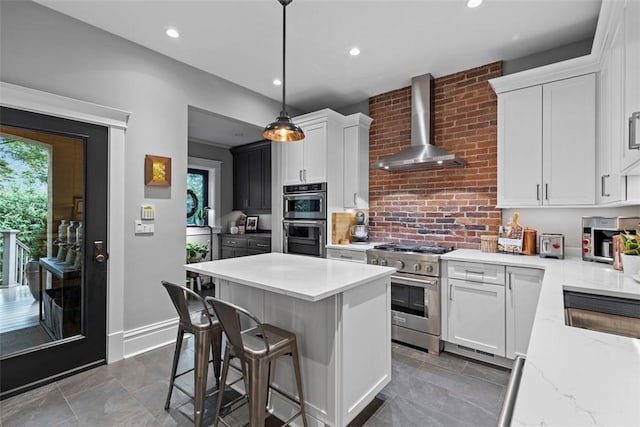 6909 Meade St, Point Breeze, PA 15208 - kitchen featuring stainless steel appliances, wall chimney exhaust hood, white cabinetry, and recessed lighting