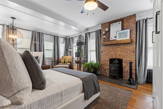 6909 Meade St, Point Breeze, PA 15208 - bedroom with a wood stove, ornamental molding, wood finished floors, a chandelier, and a ceiling fan