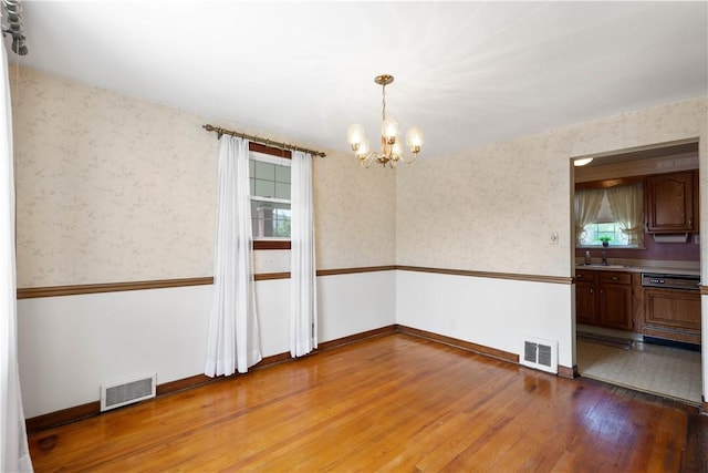 33 S Vireo Dr, Kennedy Twp, PA 15136 - spare room featuring a chandelier, light wood-type flooring, and wallpapered walls