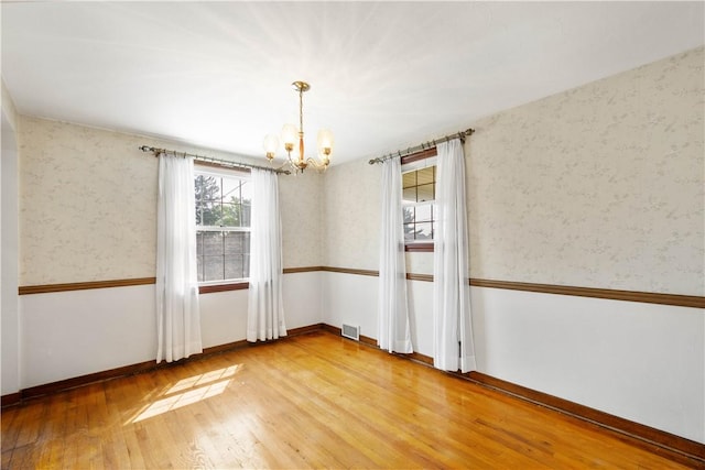 33 S Vireo Dr, Kennedy Twp, PA 15136 - spare room featuring a chandelier, light wood-style flooring, and wallpapered walls