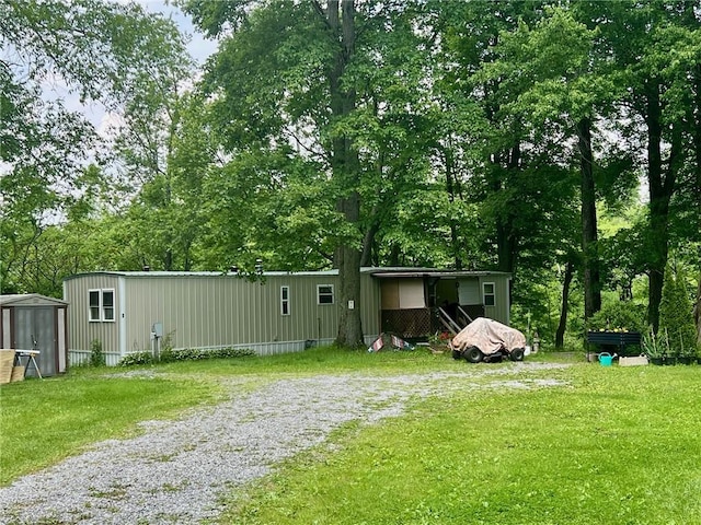 25 Coolspring St, Coolspring Twp, PA 16137 - view of grassy yard with view of wooded area, a storage shed, and gravel driveway