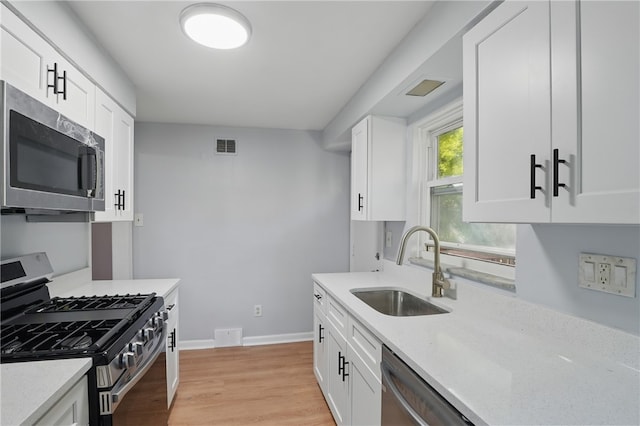 3917 Beechwood Blvd, Squirrel Hill, PA 15217 - kitchen featuring appliances with stainless steel finishes, light wood-type flooring, and white cabinetry