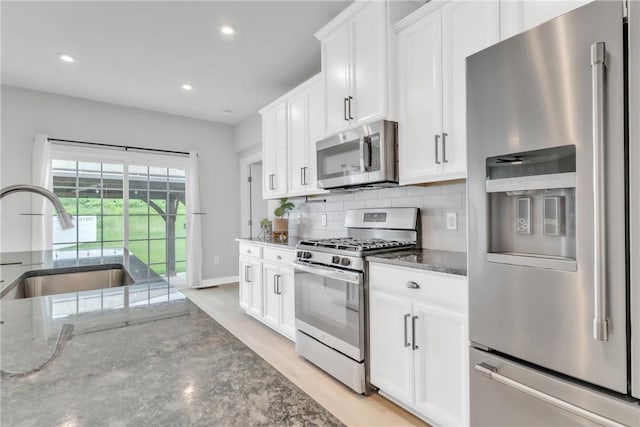 313 Camden Dr, Lehigh Twp, PA 16063 - kitchen with stainless steel appliances, dark stone counters, tasteful backsplash, white cabinets, and recessed lighting
