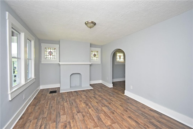 2300 Palm Beach Ave, Beechview, PA 15216 - unfurnished living room featuring arched walkways, dark wood-style floors, and a textured ceiling