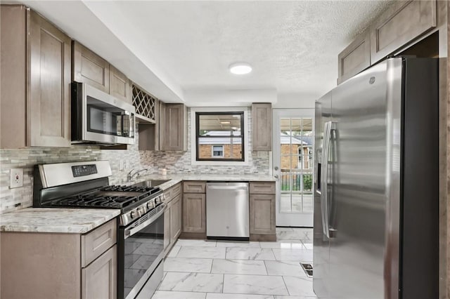 330 Delaney Dr, Wilkins Twp, PA 15235 - kitchen featuring stainless steel appliances, light marble finish floors, backsplash, a textured ceiling, and light stone counters