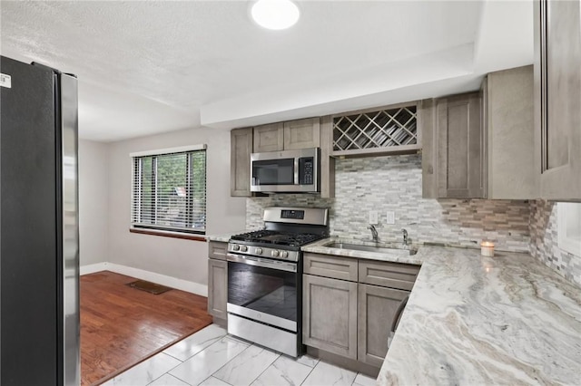 330 Delaney Dr, Wilkins Twp, PA 15235 - kitchen featuring stainless steel appliances, tasteful backsplash, light stone counters, and light marble finish flooring