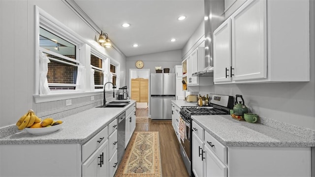 1451 Keystone St, Natrona Hts/Harrison Twp, PA 15065 - kitchen with stainless steel appliances, white cabinetry, wood finished floors, vaulted ceiling, and wall chimney range hood
