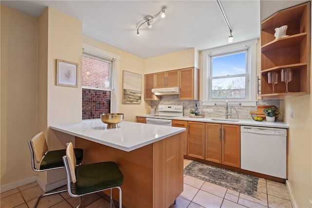 3485 Beechwood Blvd, Greenfield, PA 15217 - kitchen with white appliances, under cabinet range hood, tasteful backsplash, light countertops, and a kitchen breakfast bar