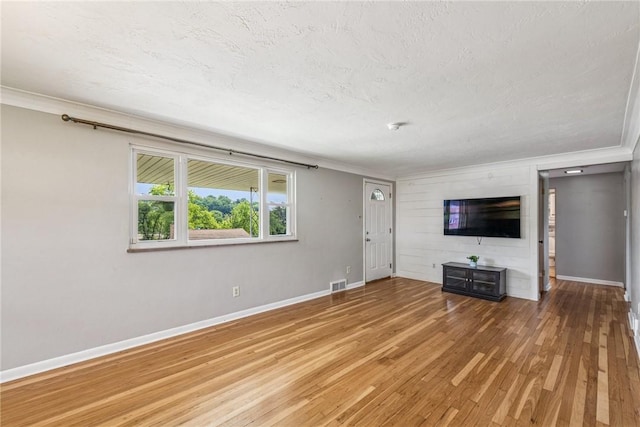 4100 Burnsire Dr, Hempfield Twp Wml, PA 15642 - unfurnished living room featuring ornamental molding, light wood-style floors, and a textured ceiling