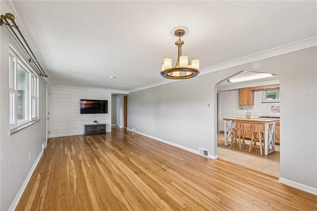 4100 Burnsire Dr, Hempfield Twp Wml, PA 15642 - unfurnished living room with arched walkways, light wood-style floors, a chandelier, and ornamental molding