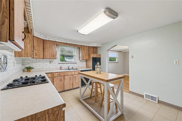 4100 Burnsire Dr, Hempfield Twp Wml, PA 15642 - kitchen with gas cooktop, oven, arched walkways, decorative backsplash, and light countertops