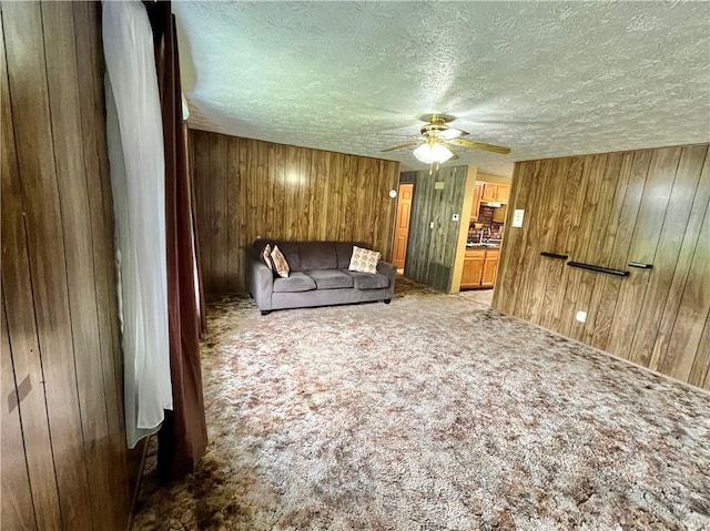 1974 Tara Dr, North Huntingdon, PA 15642 - living area featuring carpet floors, ceiling fan, wood walls, and a textured ceiling