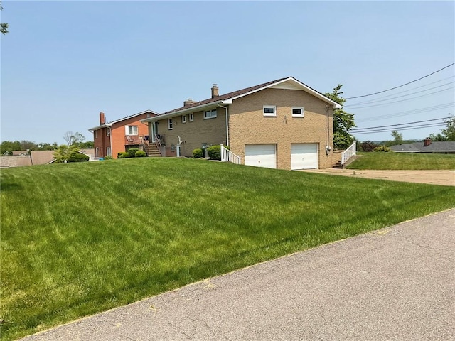 143 Herbst Rd, Kennedy Twp, PA 15108 - view of front facade featuring an attached garage, a chimney, a front yard, driveway, and brick siding