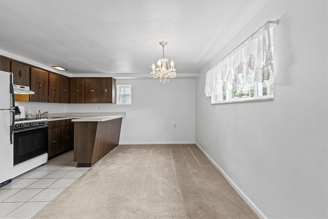 737 Spring Grove Rd, Ohara, PA 15215 - kitchen with under cabinet range hood, gas stove, a chandelier, light countertops, and dark brown cabinets
