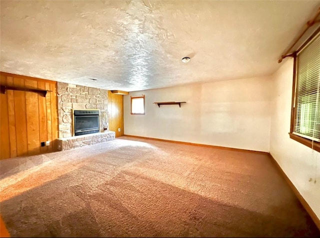 201 Esther Ave, New Kensington, PA 15068 - unfurnished living room with carpet, a stone fireplace, wooden walls, and a textured ceiling