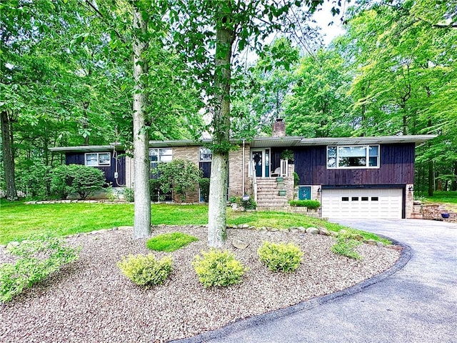 315 Lake Dr, Neshannock Twp, PA 16105 - bi-level home featuring asphalt driveway, a chimney, an attached garage, and a front lawn