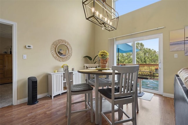 23 Sunset Ct, Cranberry Twp, PA 16066 - dining space featuring wood finished floors, a towering ceiling, and a chandelier