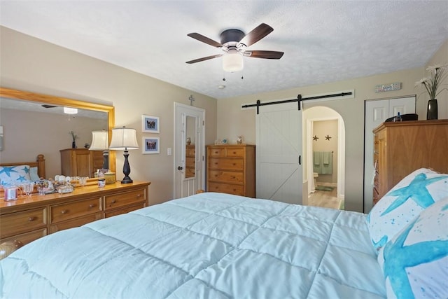 23 Sunset Ct, Cranberry Twp, PA 16066 - bedroom featuring a barn door, ceiling fan, and ensuite bath