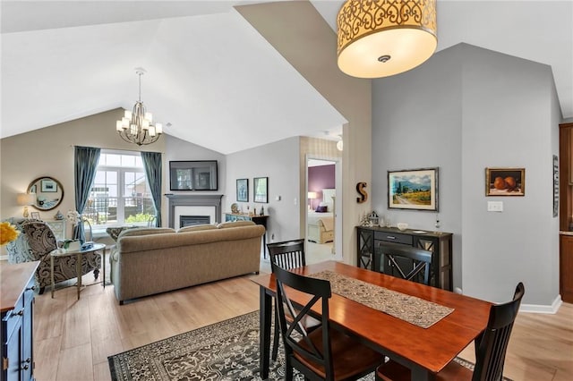 1041 Clerkenwell Ln, Cranberry Twp, PA 16066 - dining space with a chandelier, light wood-style flooring, a fireplace, and high vaulted ceiling