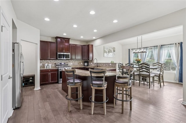2811 De Paul Ct, Franklin Park, PA 15143 - kitchen with stainless steel appliances, a breakfast bar area, backsplash, wood-type flooring, and recessed lighting