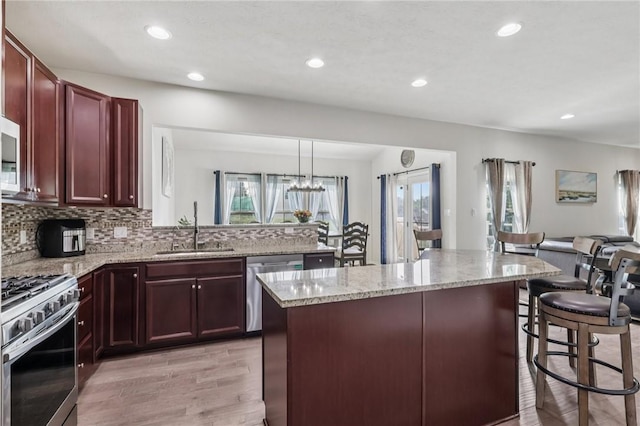 2811 De Paul Ct, Franklin Park, PA 15143 - kitchen with stainless steel appliances, a kitchen breakfast bar, light wood finished floors, healthy amount of natural light, and recessed lighting