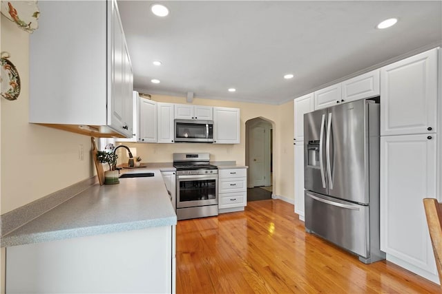 108 Mary St, Ross Twp, PA 15214 - kitchen with stainless steel appliances, arched walkways, recessed lighting, light countertops, and white cabinetry